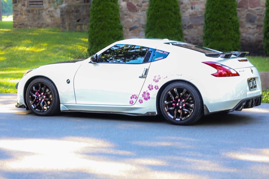 Rear-quarter view of the 370Z showing the ducktail spoiler, pink brake calipers and hibiscus decals.